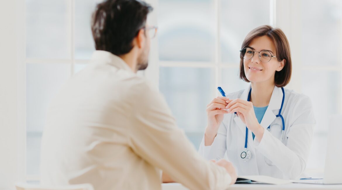 Skilled therapist in white uniform talks with patient